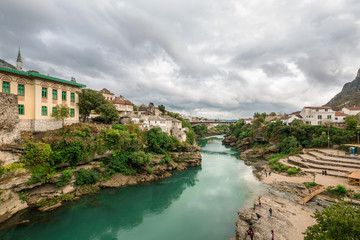 Fototapeta na wymiar The World Heritage Site Old Bridge Of Mostar City With Emerald River Neretva In Southern Part Of Bosnia-Herzegovina In Eastern Europe Where West Meets East