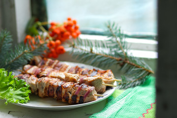 Pork shish kebab with fir branches, rowan and green leaf of lettuce cooked on the grill for Christmas dinner for the designer