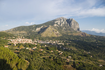 Obraz premium Das Bergmassiv Monte Bulgheria im Cilento in der Morgensonne vor Olivenheinen, Weinreben und dem Ort San Giovanni a Pirlo