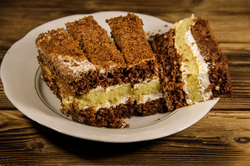 Sour cream cake on plate on wooden table
