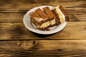 Sour cream cake on plate on wooden table