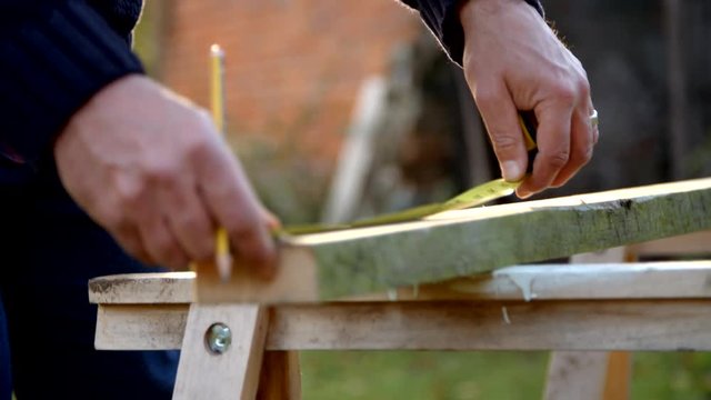 Mature Man Measuring And Sawing Wood In Slow Motion