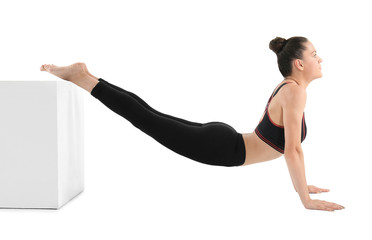 Young beautiful woman doing yoga pose with cube on white background