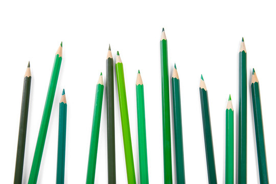 Green pencils of different shades on white background