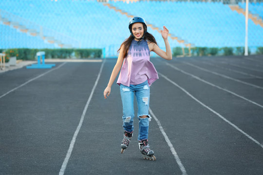 Young woman rollerskating on stadium track