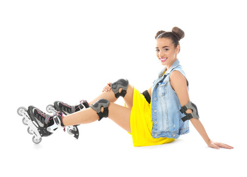 Beautiful young woman on roller skates against white background