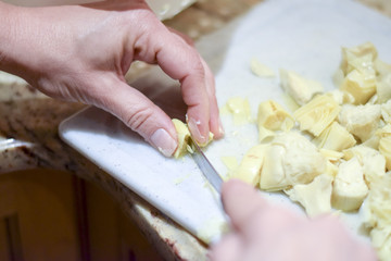 Obraz premium Hands cutting canned artichokes