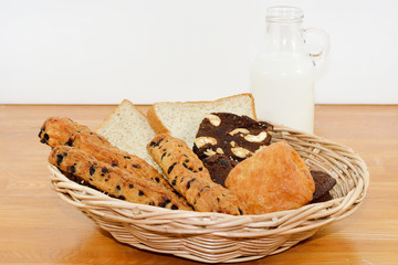 Fresh bread and pastry with milk on jug