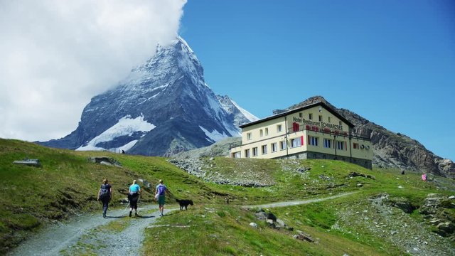 Female hikers on trail Matterhorn and hotel restaurant in background - Shot on RED Digital Cinema Camera at 5K