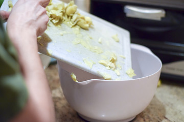 Hand scraping food into bowl