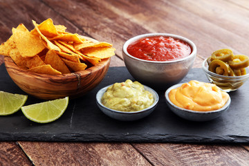 Nachos Tortilla Chips and jalapeÒos Chili Peppers or Mexican chili peppers with Tomato, Cheese and Guacamole dip