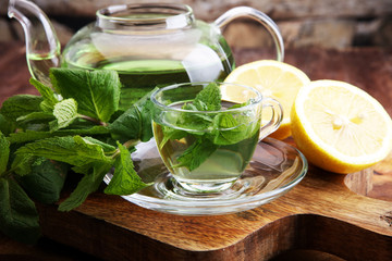 Cup of mint tea and leaves of mint on the table