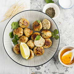 Homemade chicken meatballs with a spicy sour sweet sauce in a plate on the table. Top View.