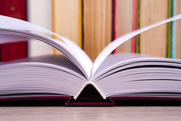 Open book, hardback books on bright colorful background.