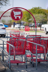 Red shopping carts on a parking lot on a sunny day.