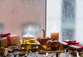 pumpkin, gifts and candles with maple leaves