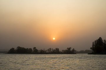 Obraz premium Sunset on the coast of the river in summer