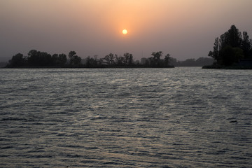 Sunset on the coast of the river in summer