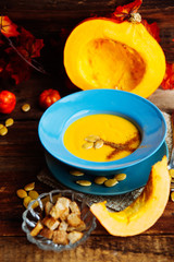 Pumpkin soup puree with spices on a wooden table