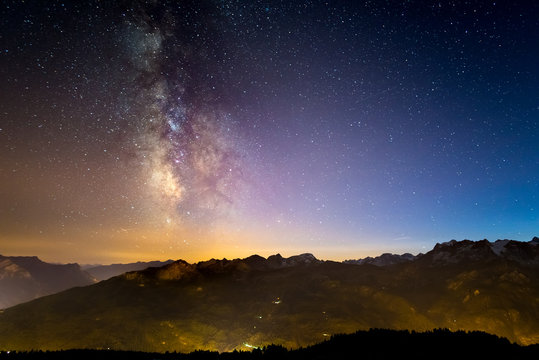 The colorful glowing Milky Way and the starry sky over the French Alps and the majestic Massif des Ecrins.
