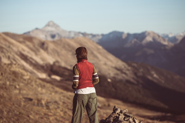 Hiker in high altitude rocky mountain landscape. Summer adventures on the Italian French Alps, toned image.