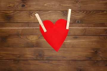 red paper heart Valentines hanging on the rope on the clothespin