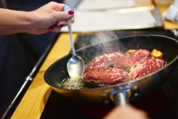 Appetizing sour steak is cooked in a frying pan. Induction cooker.