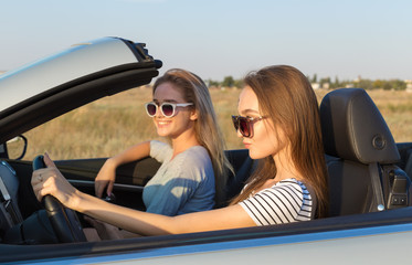 Two attractive young women in a cabriolet car