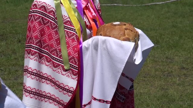 Ukrainian bread and salt in hands of women in in Ukrainian national costumes