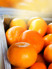 A wooden box with fresh mandarins