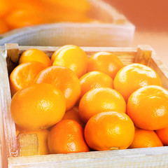 A wooden box with fresh mandarins