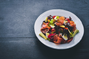 Vegetable salad and diced meat. On a wooden background. Top view. Free space.
