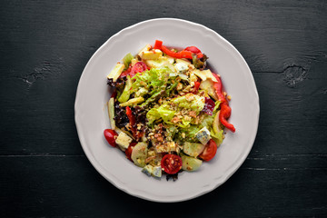 Salad of fresh vegetables and gorgonzola cheese. On a wooden background. Top view. Free space.