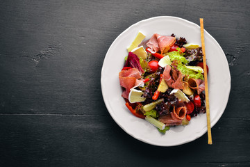 Vegetable salad and diced meat. On a wooden background. Top view. Free space.