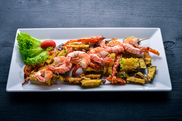 Roasted Royal Prawns with Grilled Vegetables. On a wooden background. Top view. Free space.