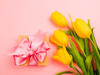 Love, romance, greetings, celebration concept - yellow tulips on pink background. delicate petals from a Tulip