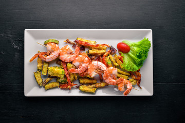 Roasted Royal Prawns with Grilled Vegetables. On a wooden background. Top view. Free space.