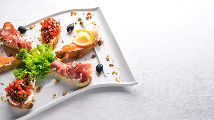 Bruschetta Sandwich with salmon and hamoon. On a wooden background. Top view. Free space.