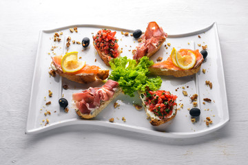 Bruschetta Sandwich with salmon and hamoon. On a wooden background. Top view. Free space.