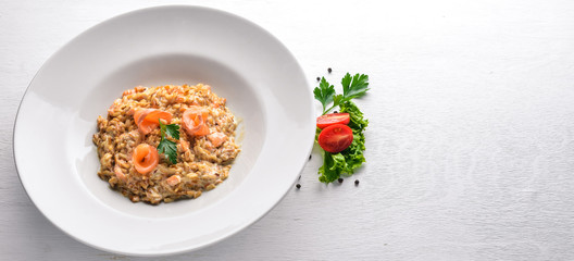 Risotto with salmon and cream sauce. On a wooden background. Top view. Free space.