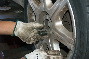 tyre repairer fixing a wheel using an impact wrench