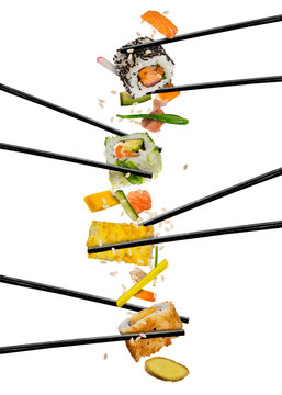 Sushi pieces placed between chopsticks, on white background