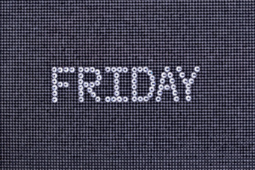 Day of the week, word FRIDAY is made rhinestones crystal color on a black canvas background.