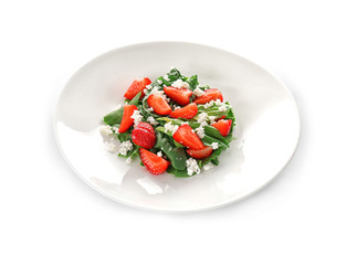 Plate with strawberry spinach salad on white background