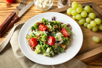 Plate with broccoli salad on table