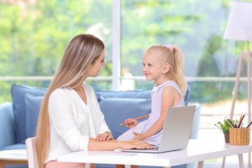 Busy young woman with her daughter at home