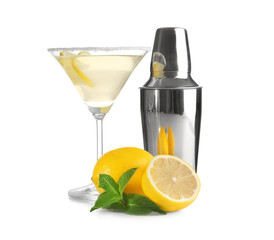 Glass of lemon drop martini, shaker and fruit on white background