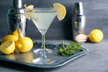 Glass of lemon drop martini with olives on metal tray