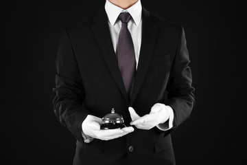 Man holding bell on black background