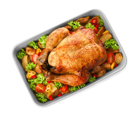 Baking dish with roasted turkey and vegetables on white background